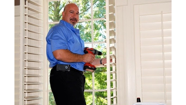 Joe Ingrassia, owner of Artistic Designs In Blinds, installing plantation shutters